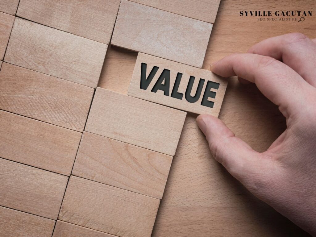 A hand fitting a wooden block labeled as "VALUE"