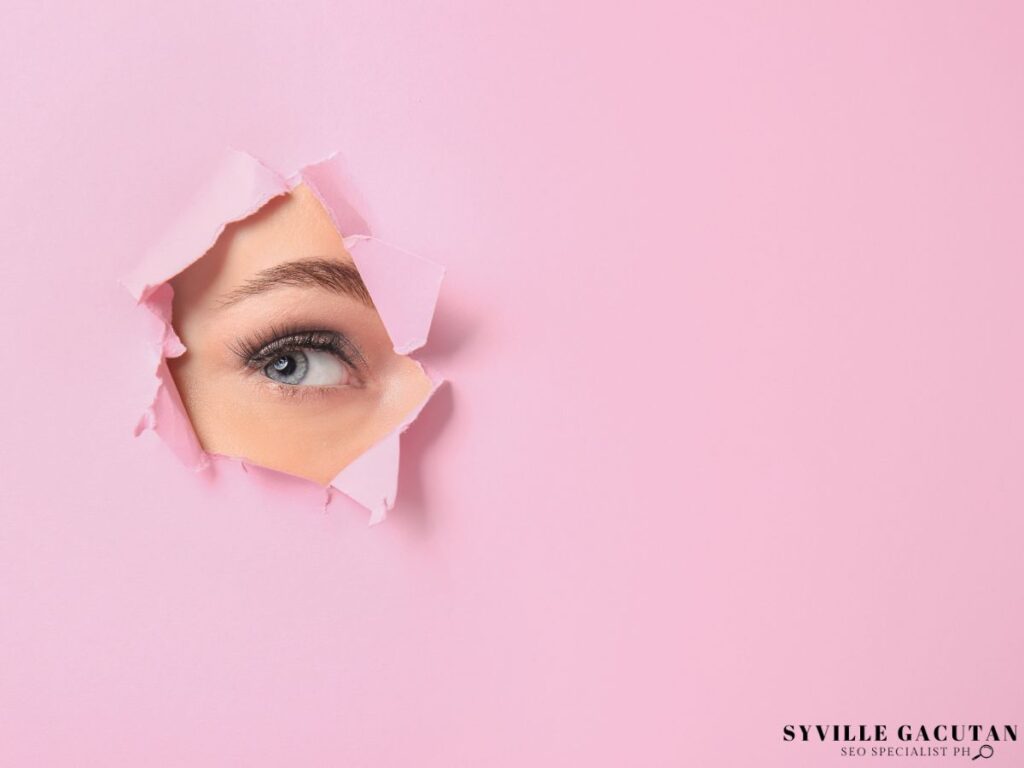 A woman's face popping out from the pink paper.