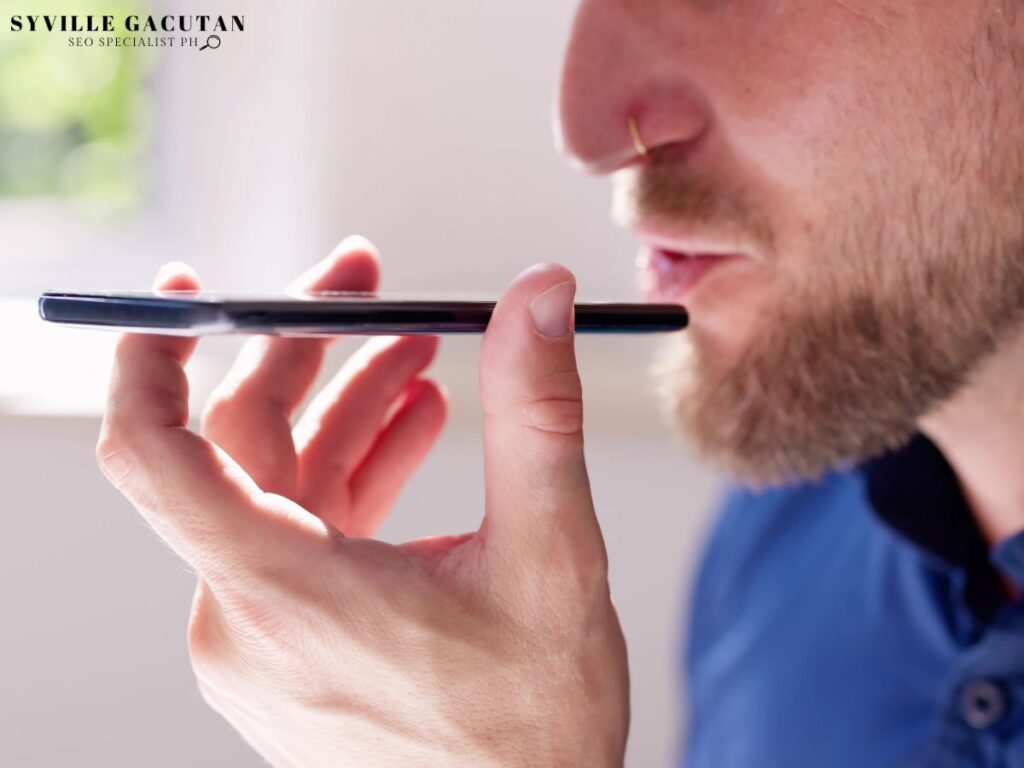 A close up of a man using voice search in his phone.