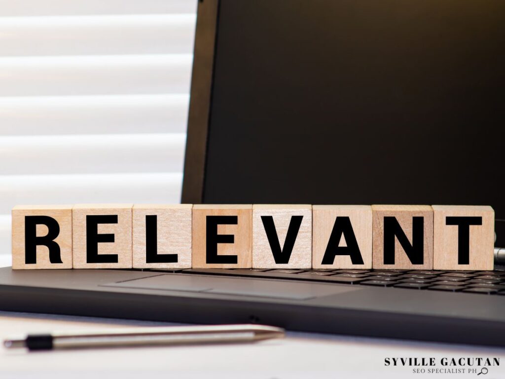 The word "RELEVANT" written on the wooden blocks placed on the laptop.