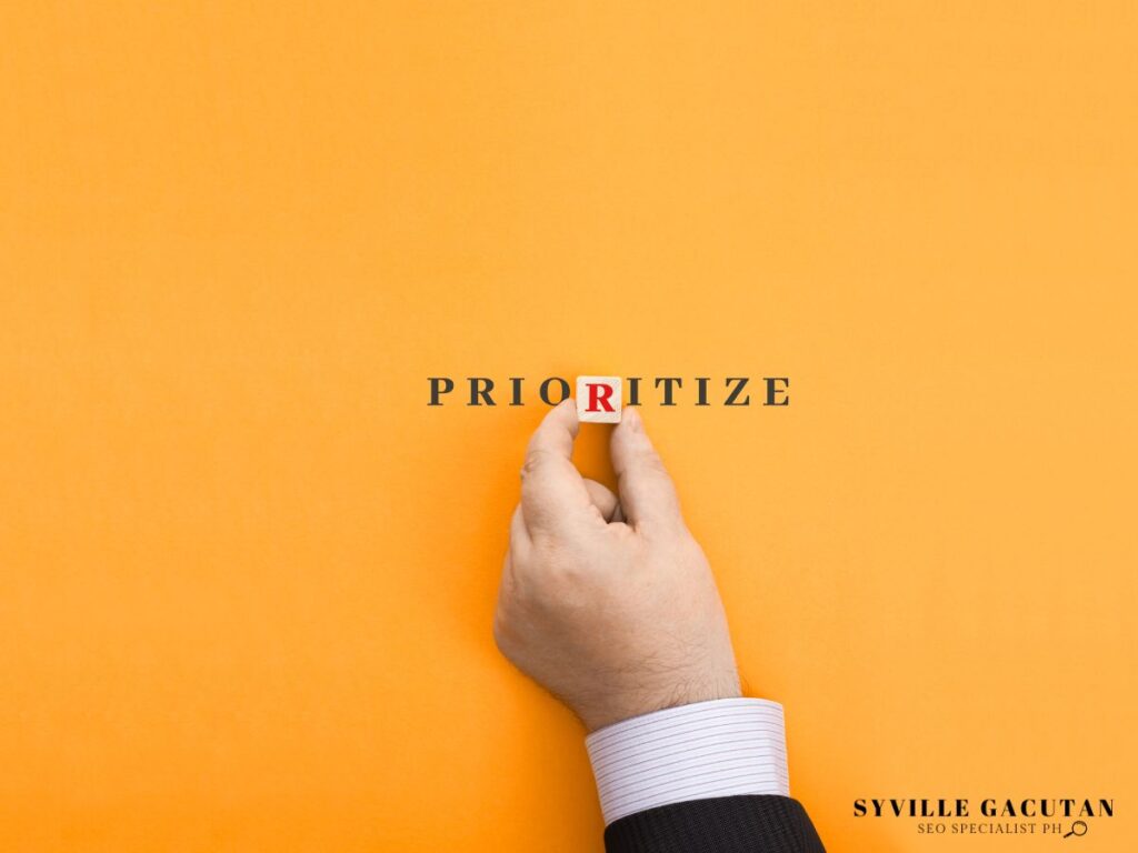 A hand placing a wodden block with letter 'R' completing the word PRIORITIZE.