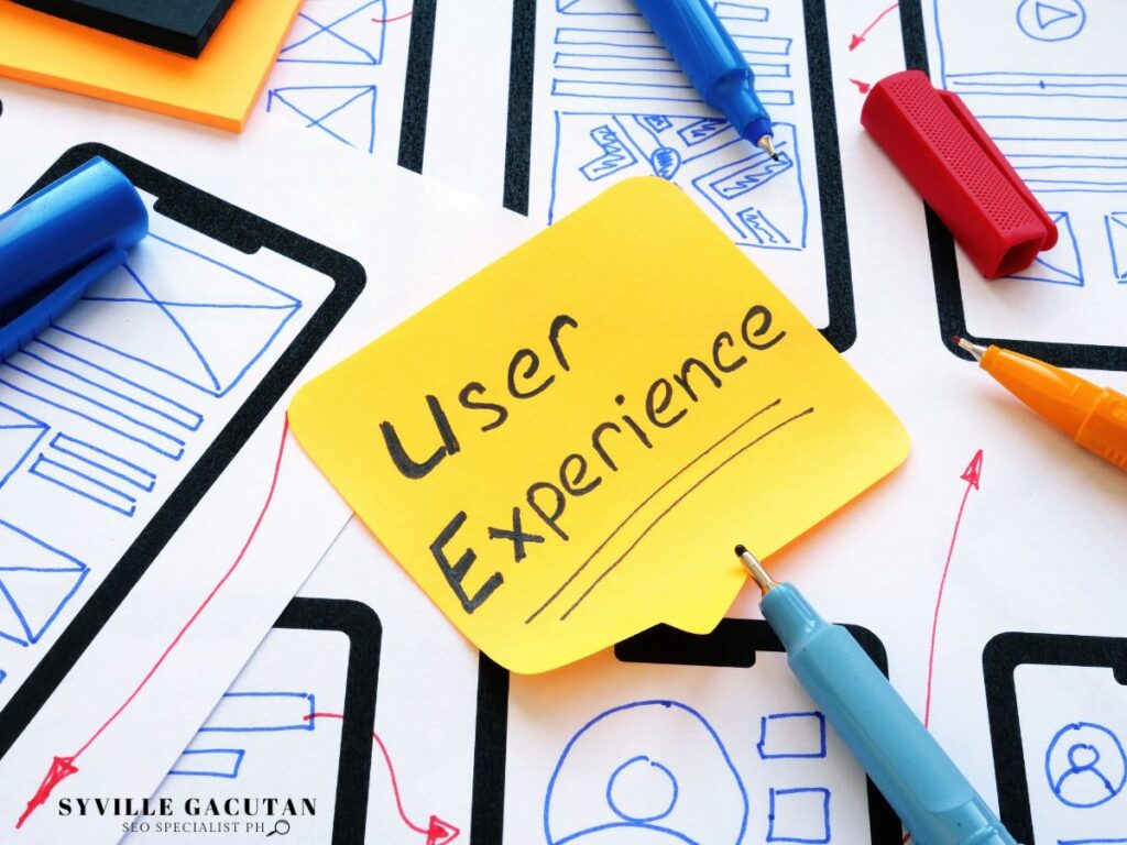 A yellow sticky note with "User Experience" written on it, surrounded by design sketches.