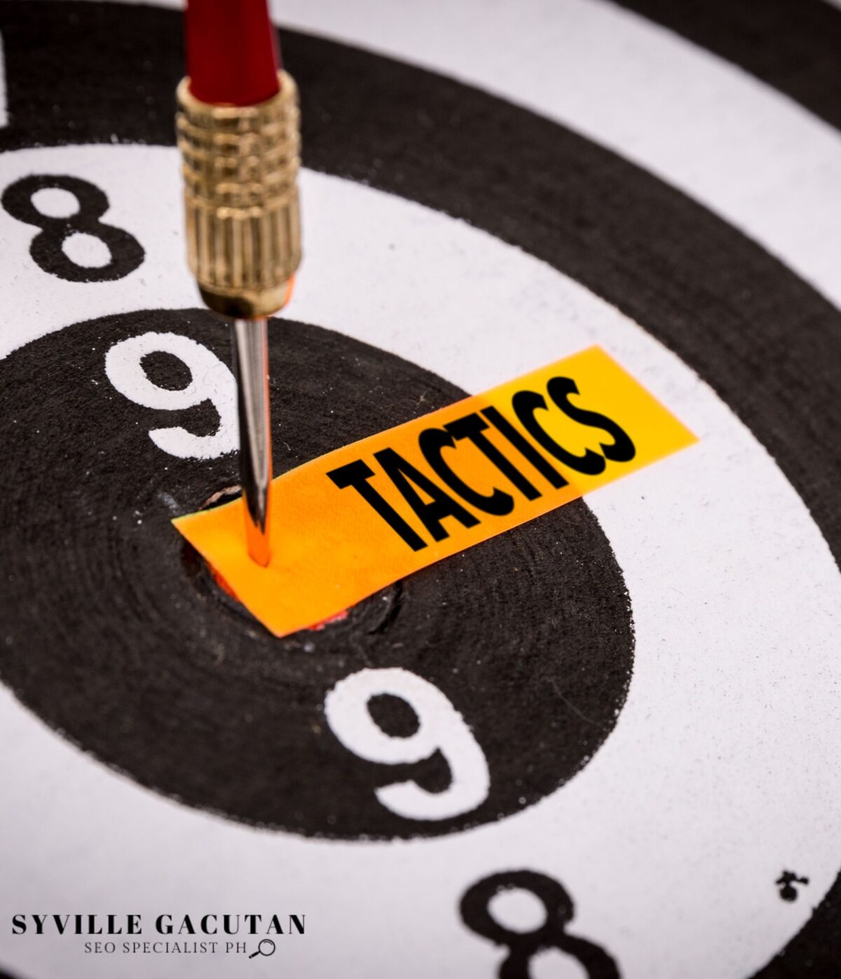 Dart on target labeled "TACTICS" on a dartboard