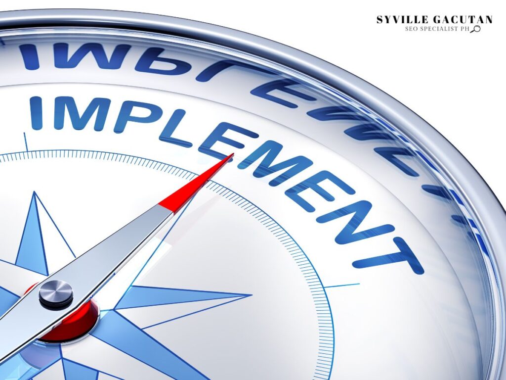 Compass with red arrow pointing to "IMPLEMENT."