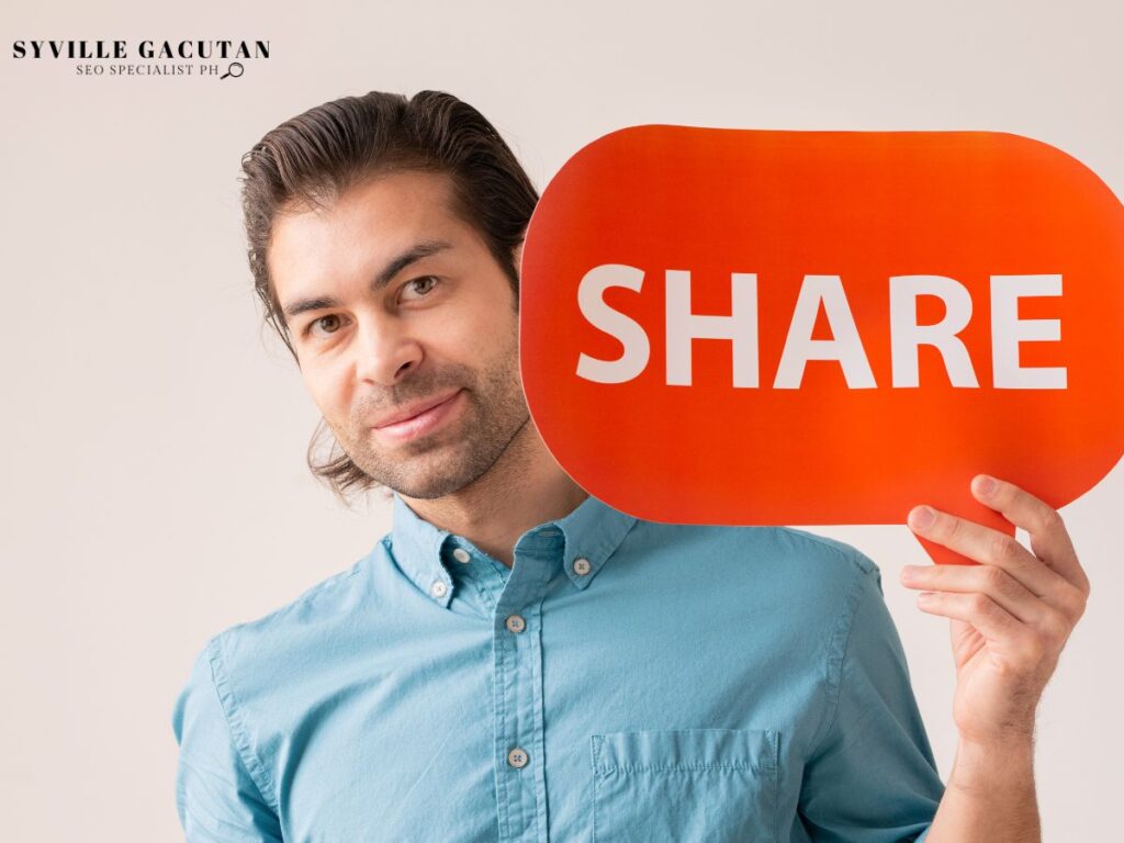 Man holding a bright red "SHARE" sign, smiling slightly at the camera.