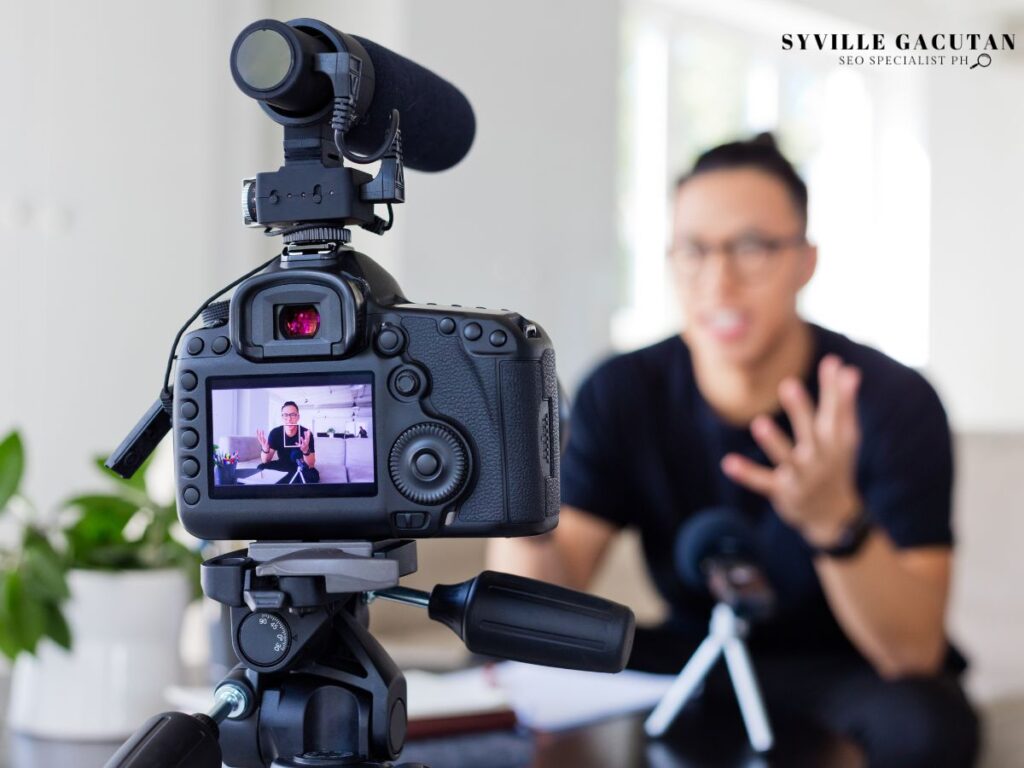 Camera filming a person talking, seen through the screen.