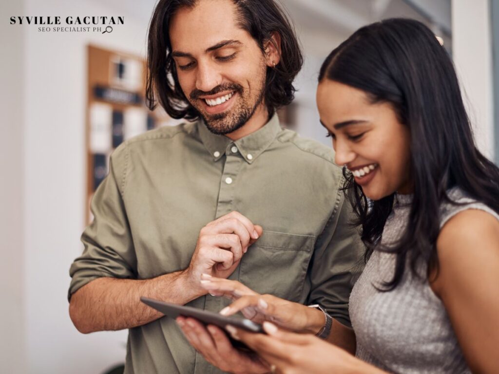 Two people sharing a tablet, smiling together