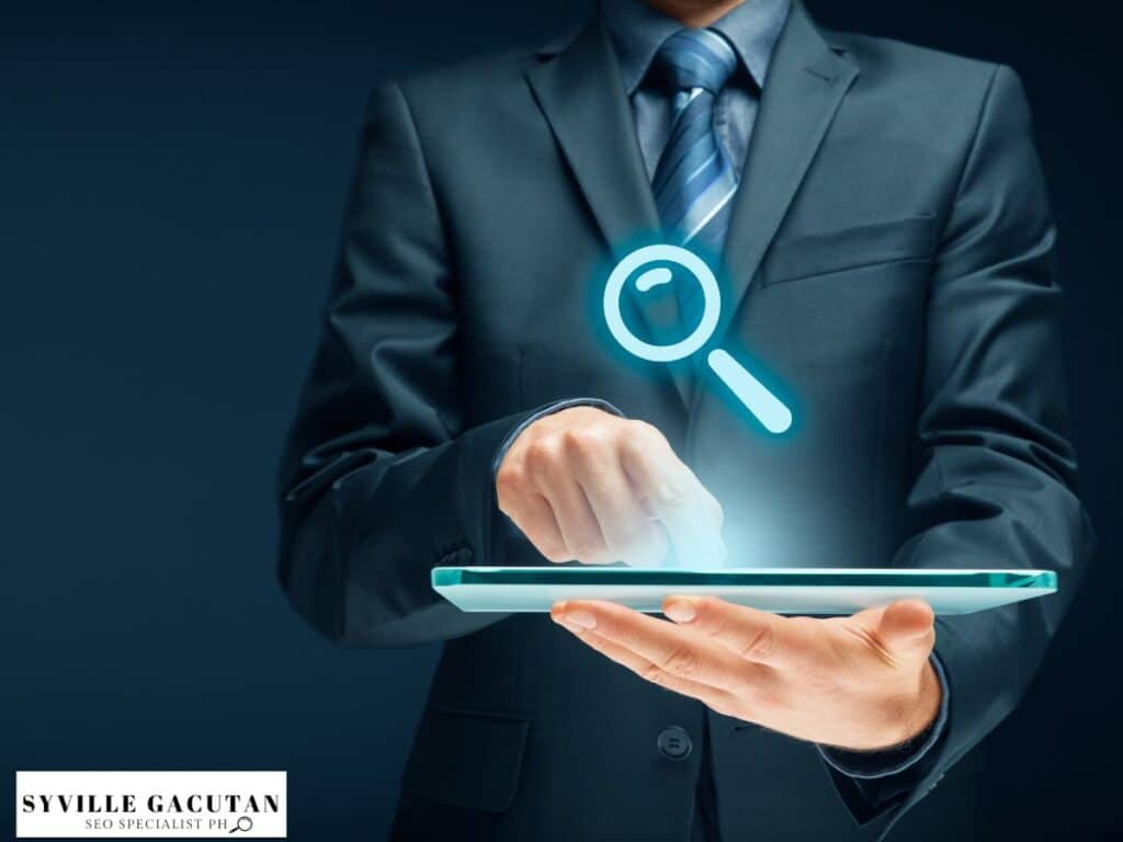 Businessman interacting with a magnifying glass icon on a tablet.