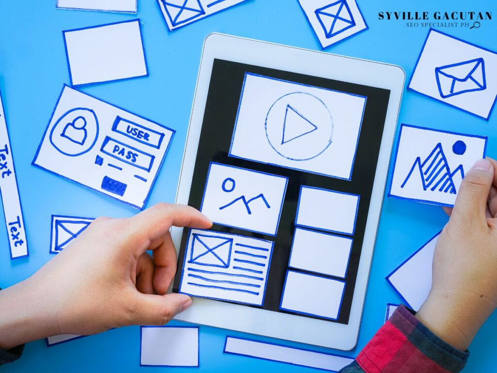 Hands arranging paper cutouts on a tablet.