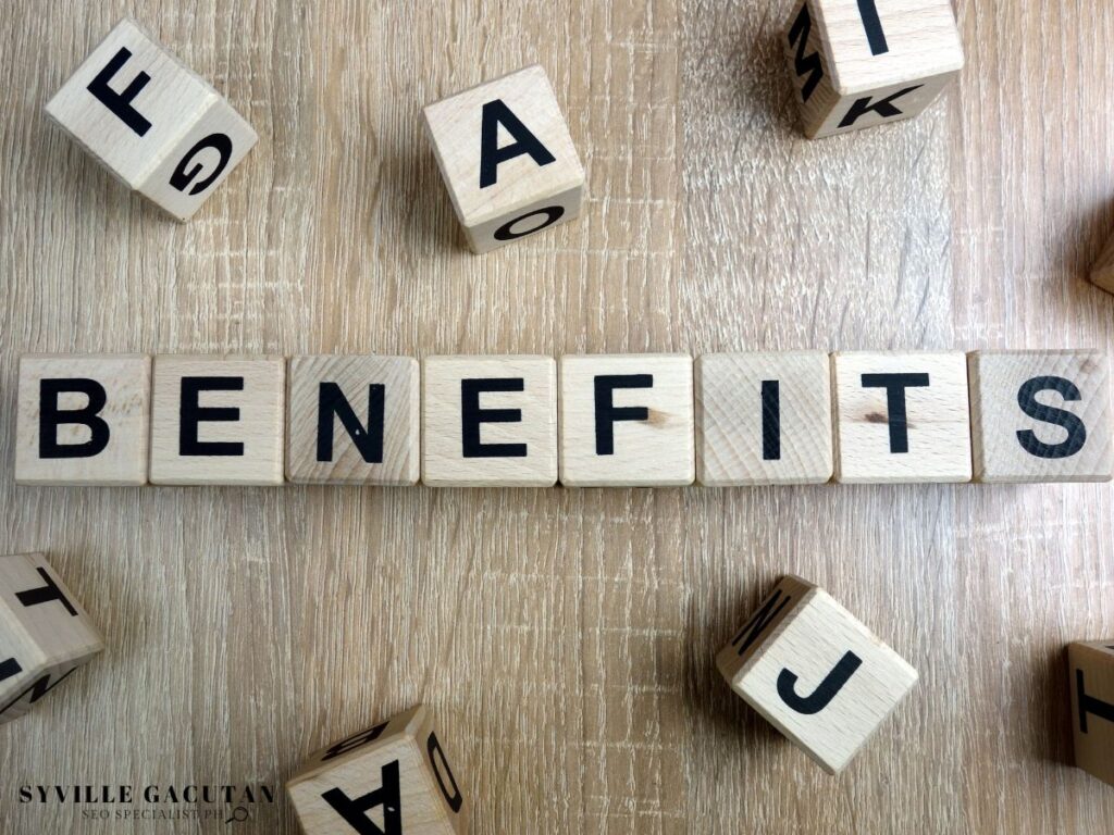 Wooden blocks spell "BENEFITS" on a wooden surface.