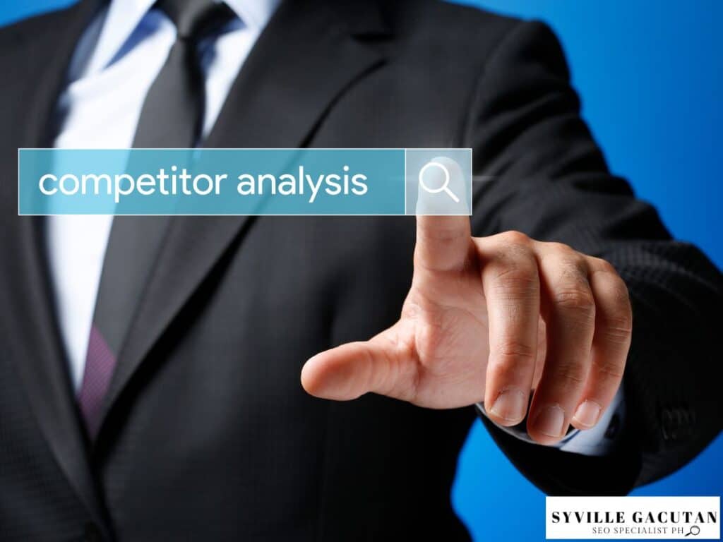 Businessman pointing at "competitor analysis" search bar.