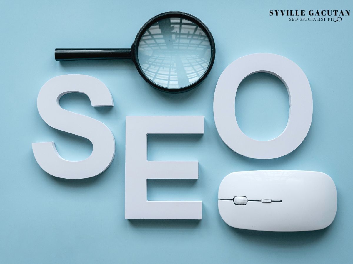 SEO letters with a magnifying glass and mouse on a light blue background.