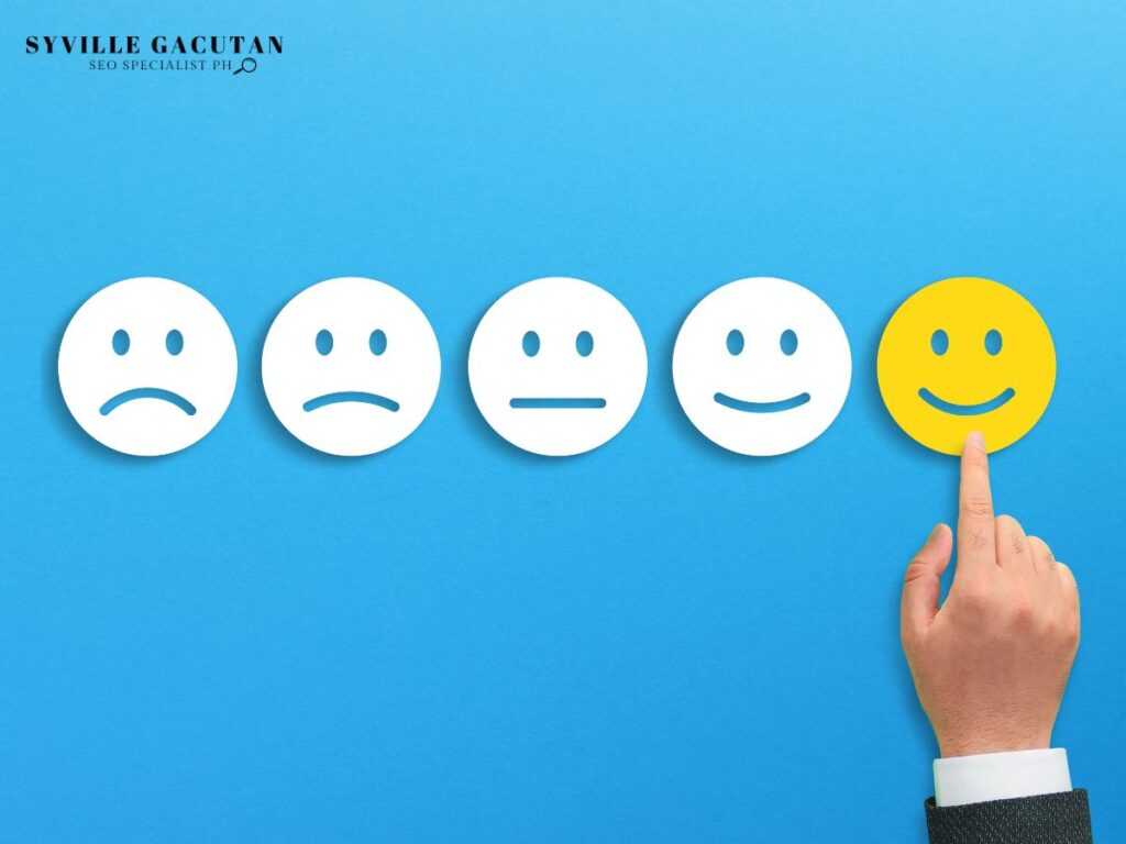 Hand pointing at a happy face among various expressions on a blue background.