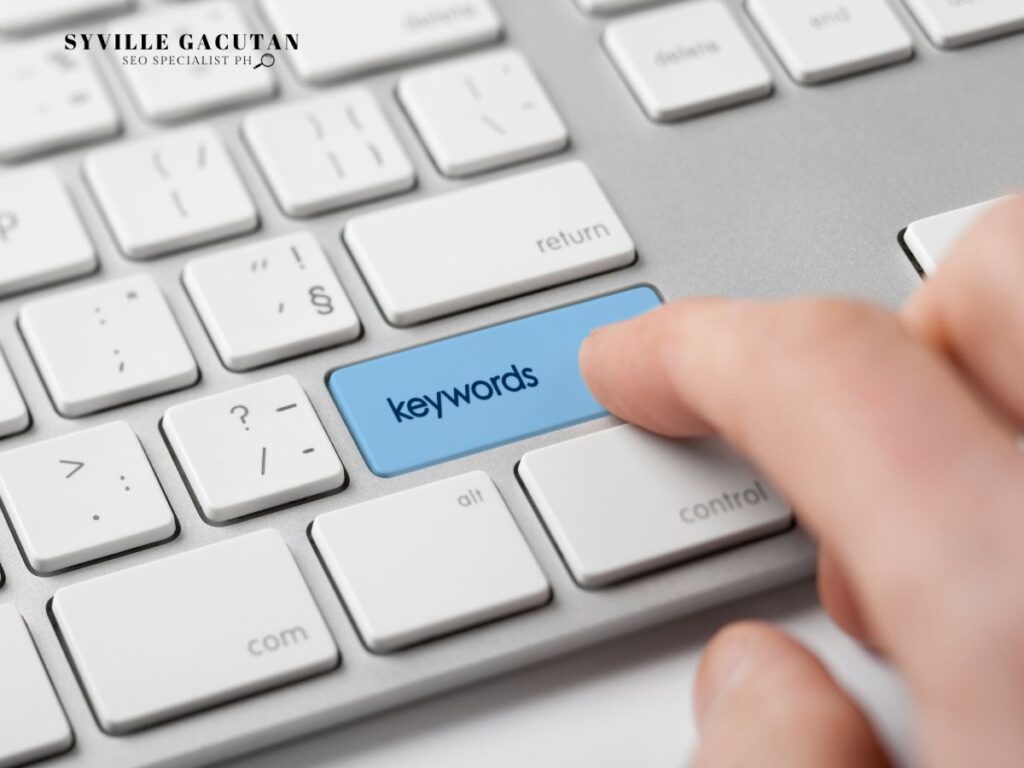 A hand pressing a blue keyboard key labeled as "Keywords"