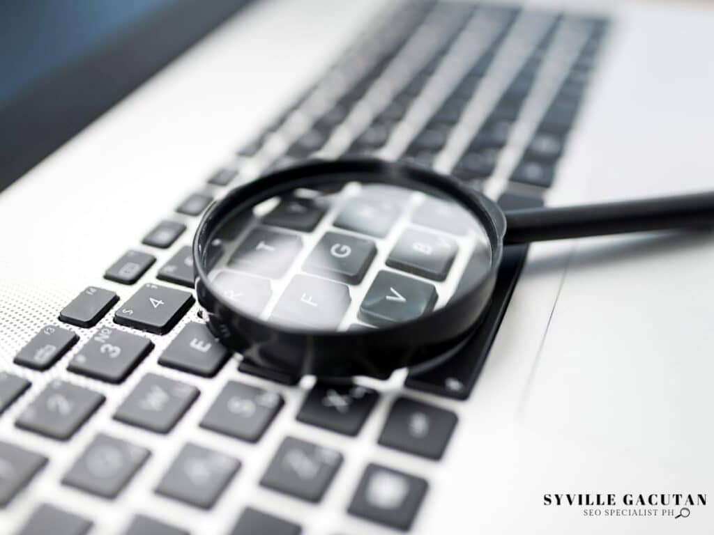 Magnifying glass placed on a laptop keyboard.