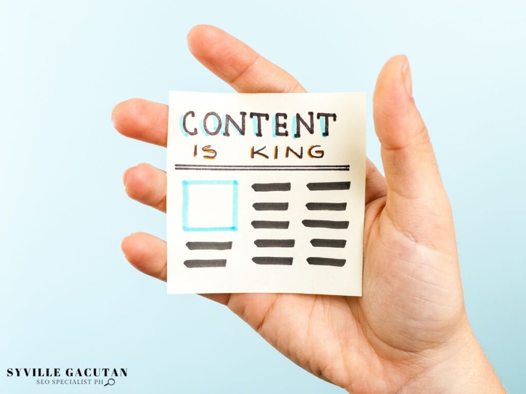 A hand holding a paper showing "CONTENT IS KING"