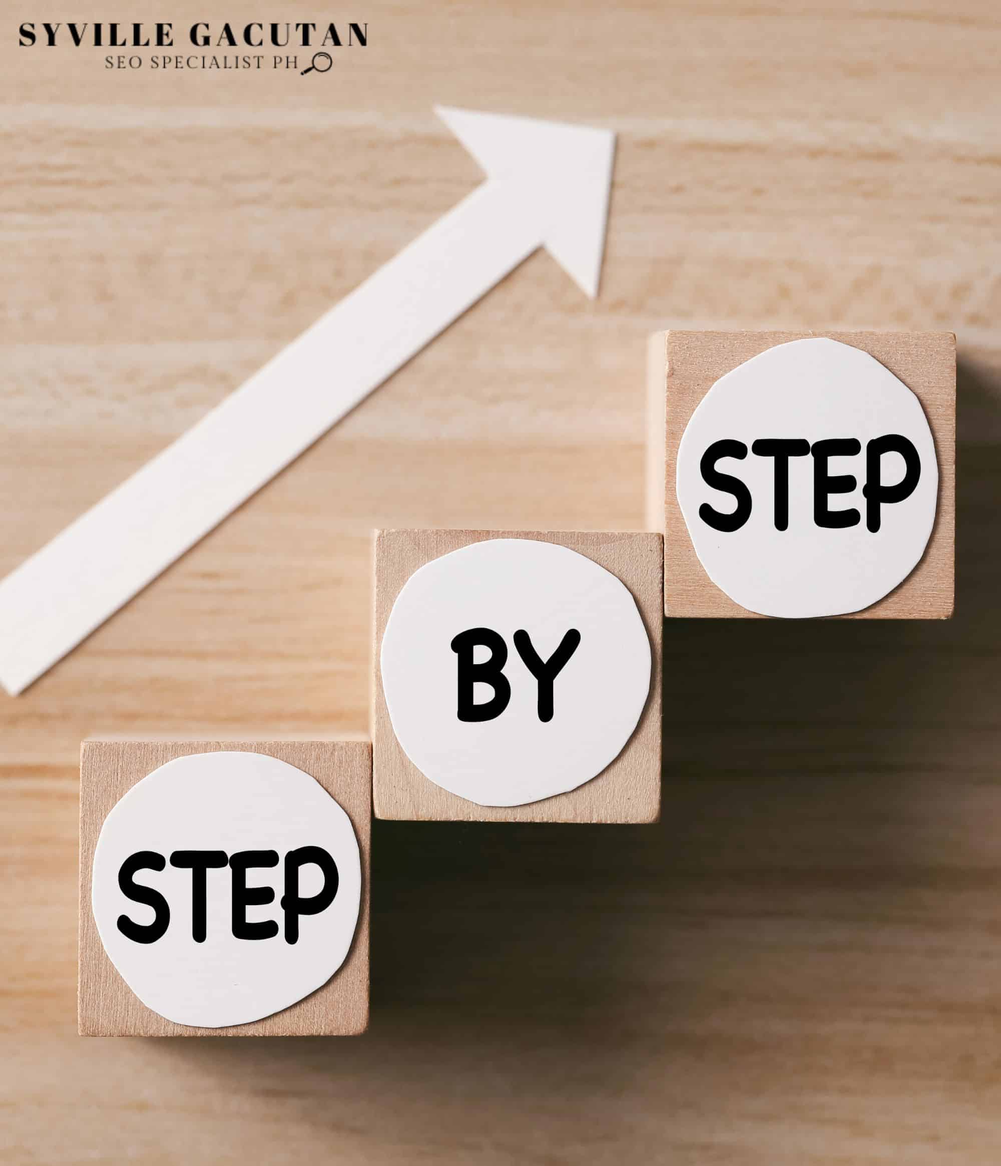 Wooden blocks with "Step by Step" text and an arrow pointing upward.