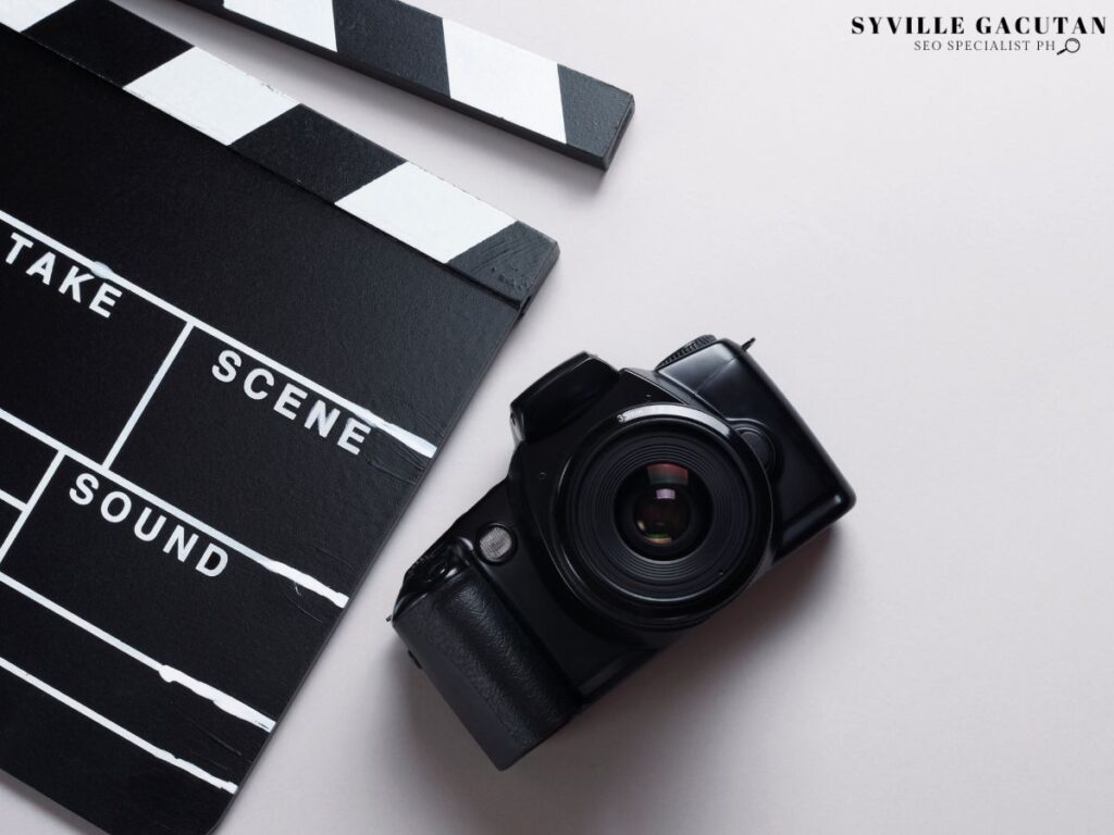A camera next to a clapperboard on a flat surface.