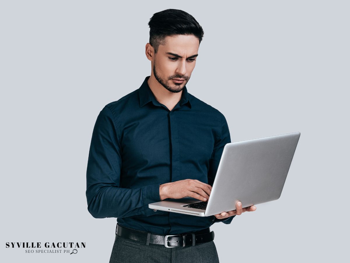 Man using laptop with serious expression.