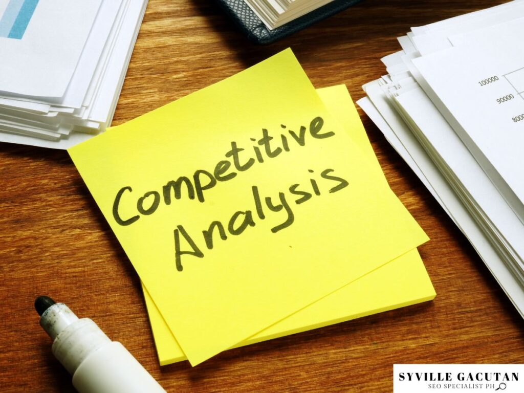 "Competitive Analysis " written on a yellow sticky note on the table.