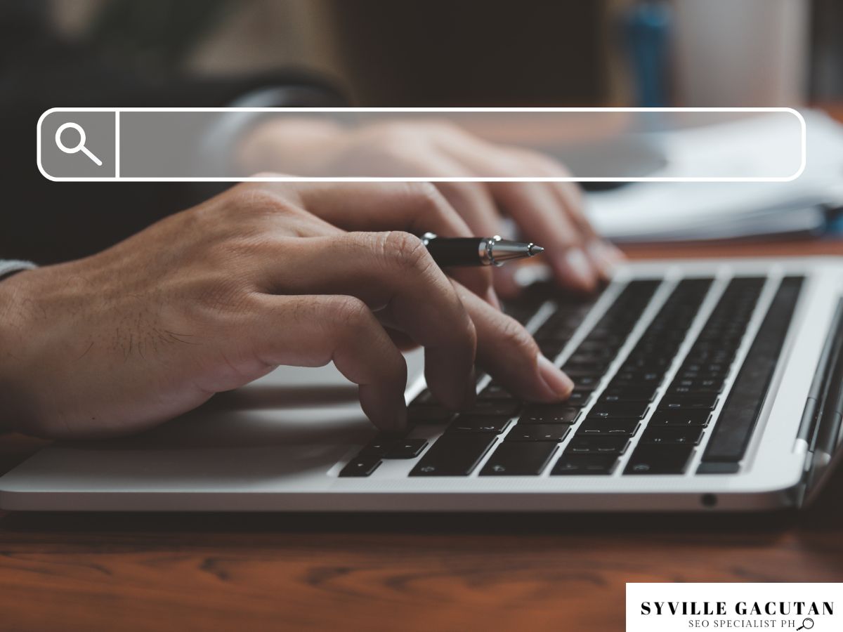 Hands typing on a laptop keyboard with a search bar overlay.