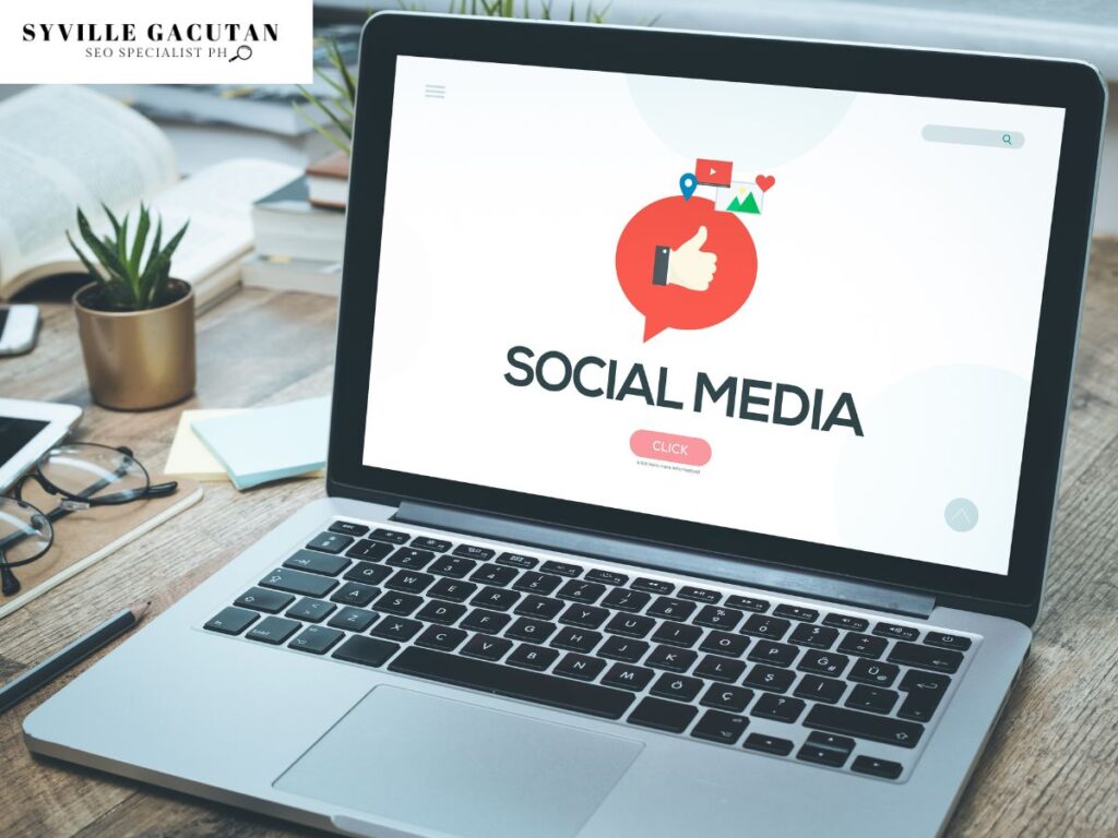 A laptop on a desk displaying "SOCIAL MEDIA" on the screen.
