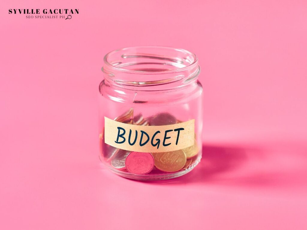 Clear jar labeled 'Budget' with coins inside.