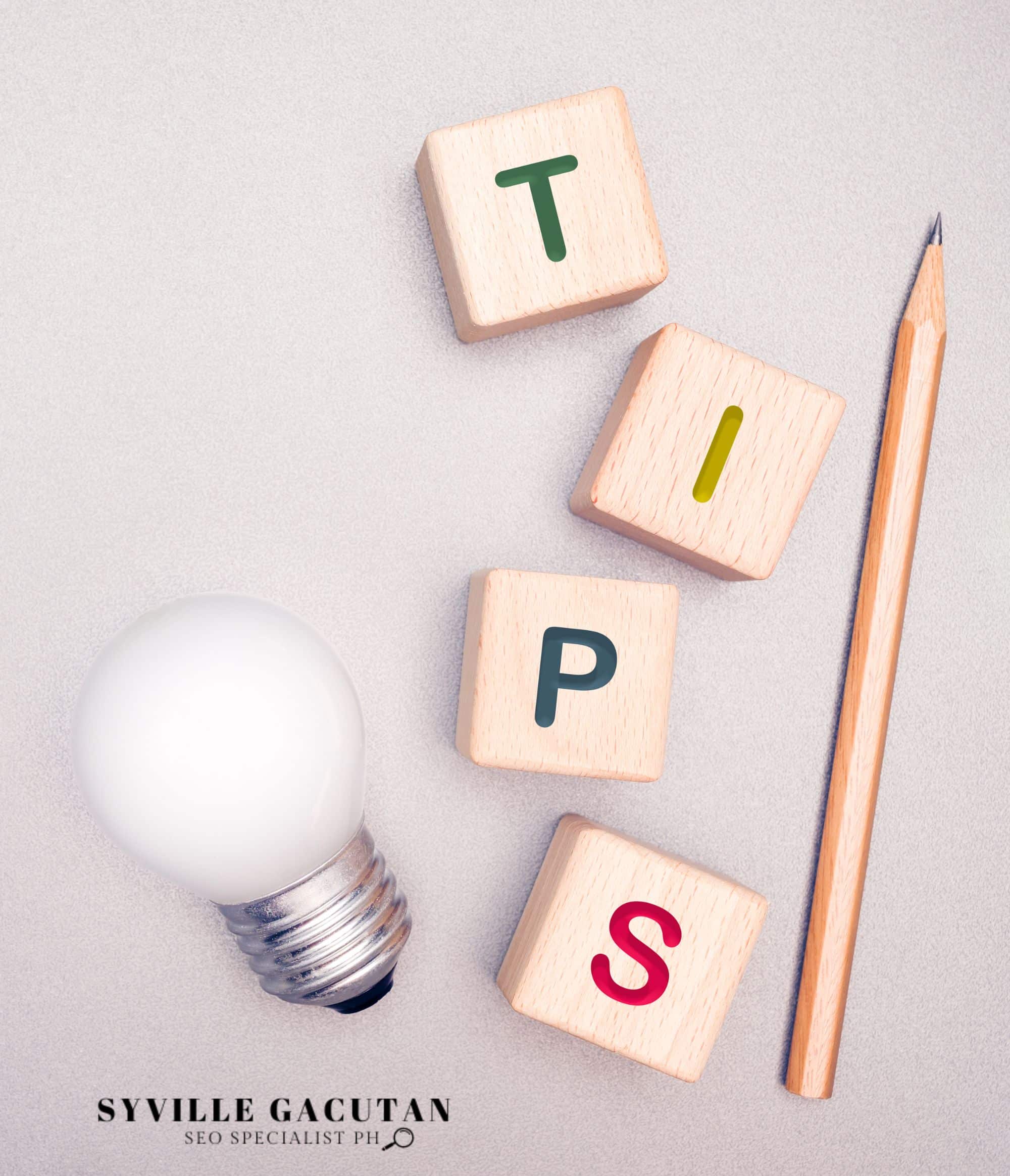 Wooden blocks spelling "TIPS" next to a light bulb and a pencil.