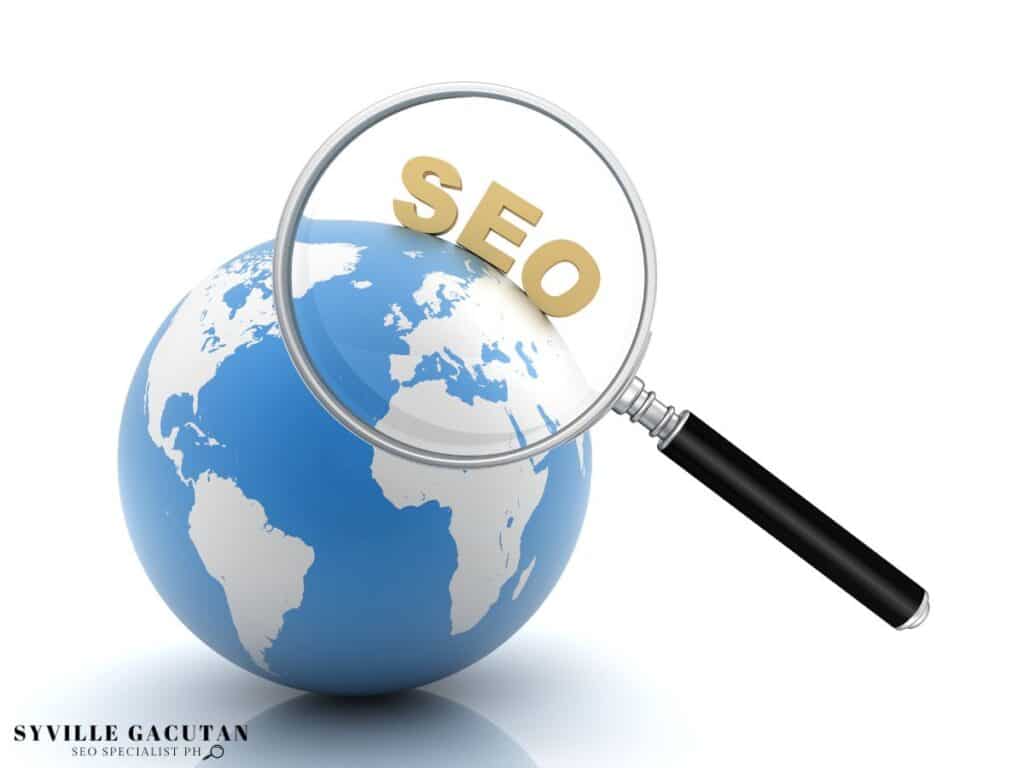 Magnifying glass over a globe with the word "SEO" displayed.