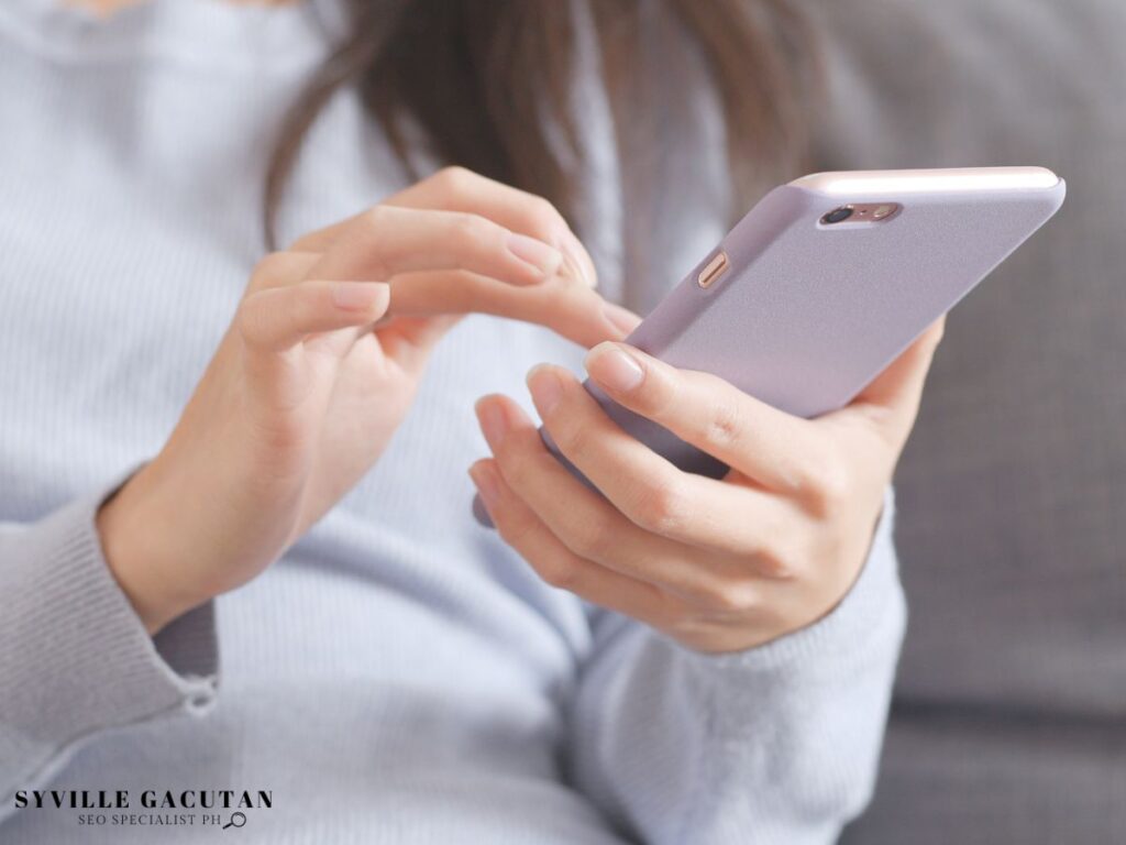 Close-up of hands using a smartphone in a casual setting.
