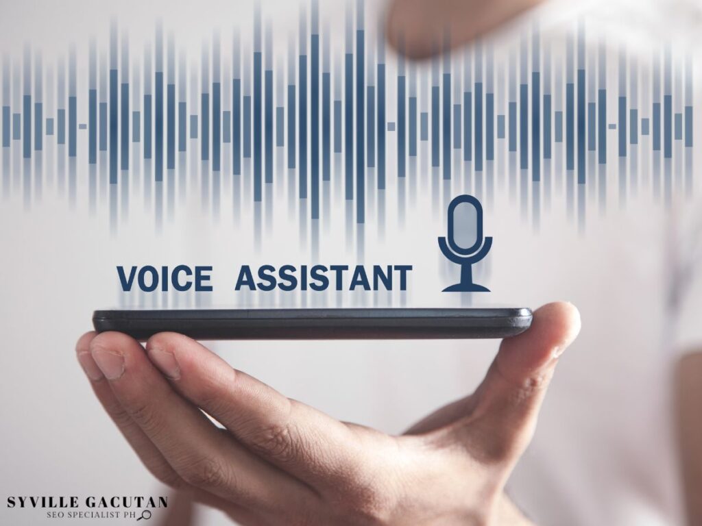 A hand holding a smartphone with a "VOICE ASSISTANT" and soundwaves above it.





