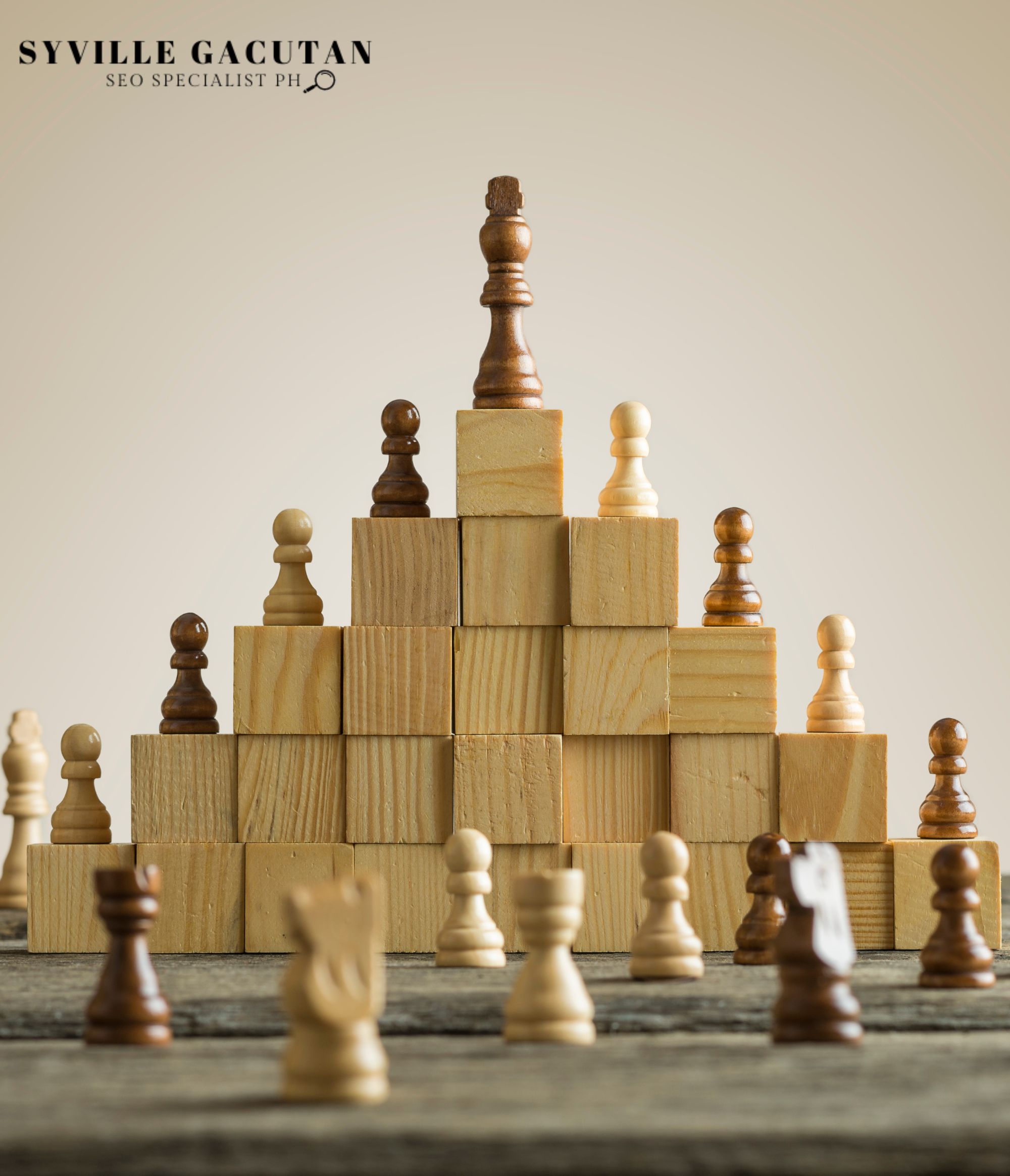Chess pieces stacked on wooden blocks, with a king on top.