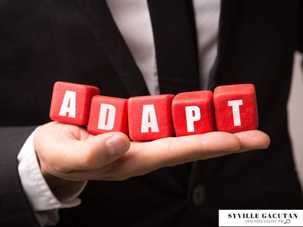 Businessman holding red blocks spelling "Adapt."