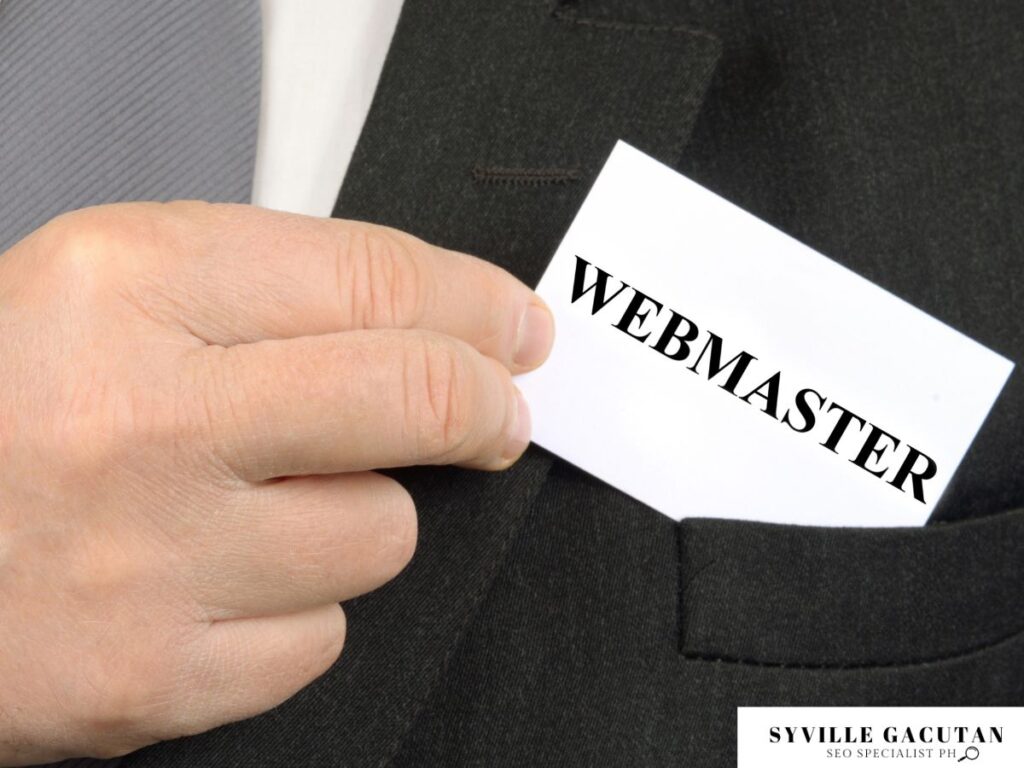 Hand holding a "Webmaster" card, ready to place in a suit pocket.