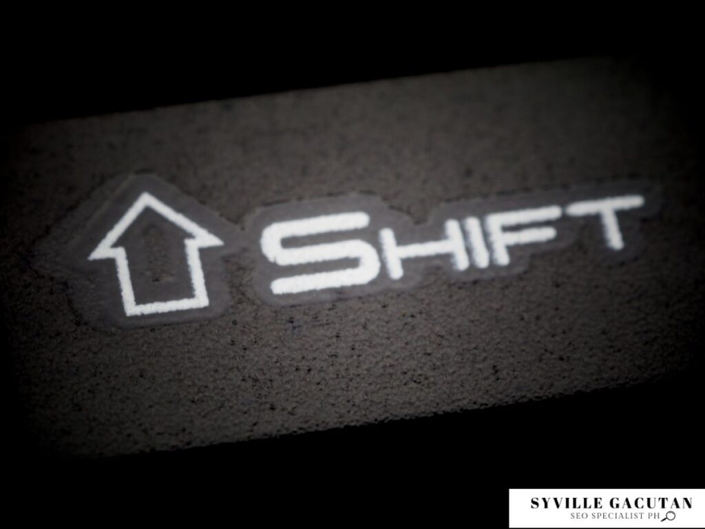 Close-up of a "Shift" keyboard key with an upward arrow.