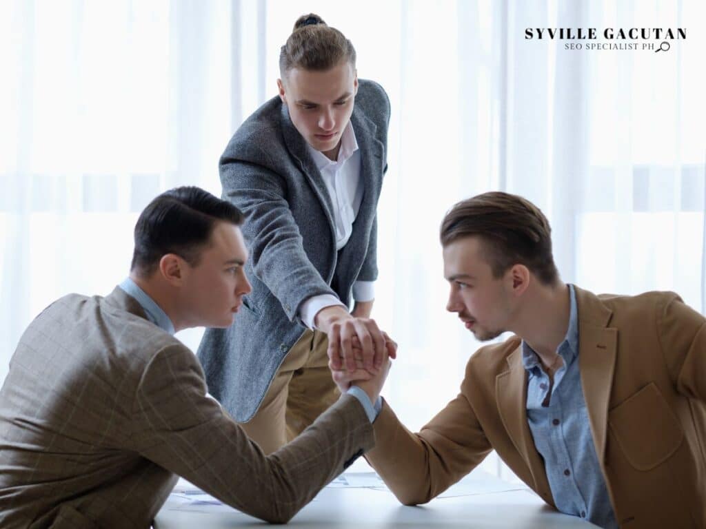 Three men arm-wrestling, showing competition and rivalry.