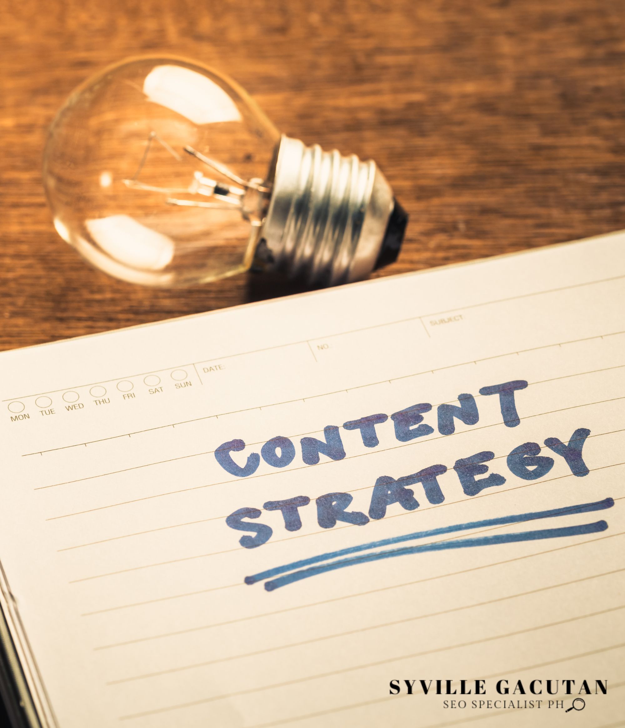 A lightbulb rests on a wooden surface beside a notebook page titled "CONTENT STRATEGY" in blue text.