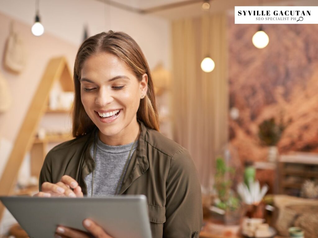 A woman working on tablet with warm lighting and cozy office interior in background.