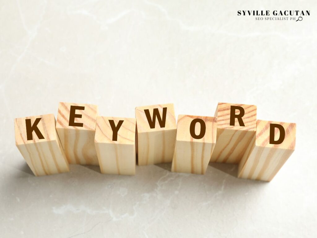 Wooden blocks spelling "Keyword" on a marble surface.