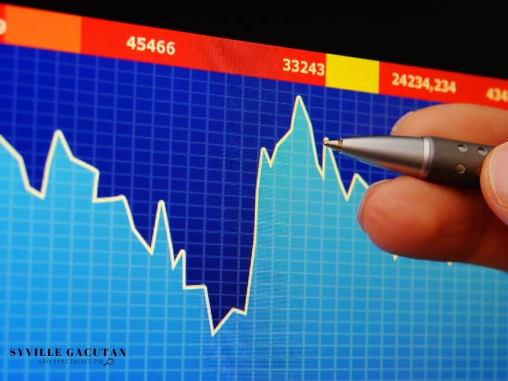 Pen pointing to a financial line graph on a screen.

