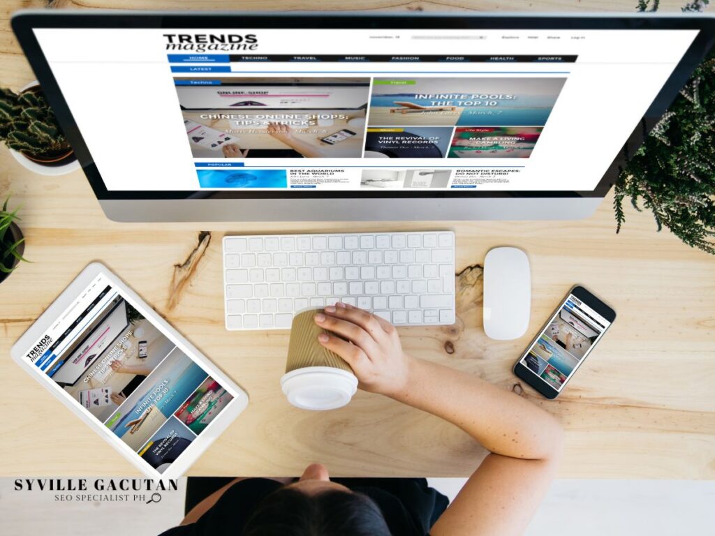 Overhead view of a desk with multiple devices showing a magazine site.
