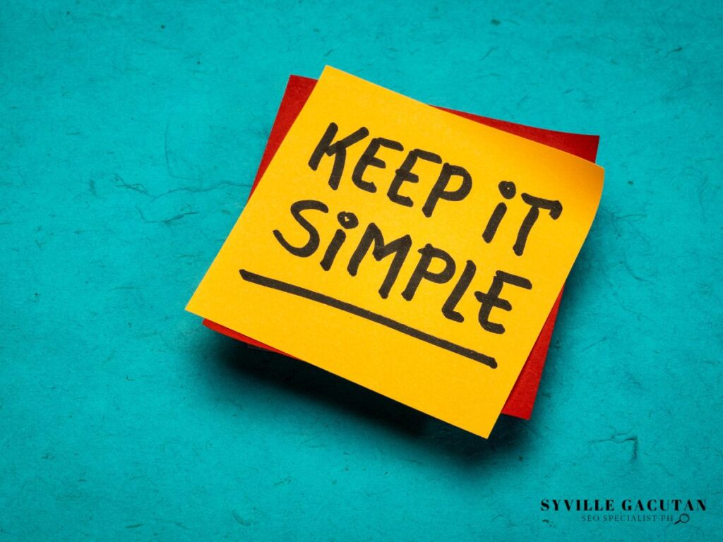 Yellow sticky note with "KEEP IT SIMPLE" handwritten text on turquoise surface.