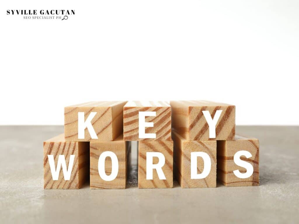 Wooden blocks spelling "KEYWORDS" stacked on a plain background.