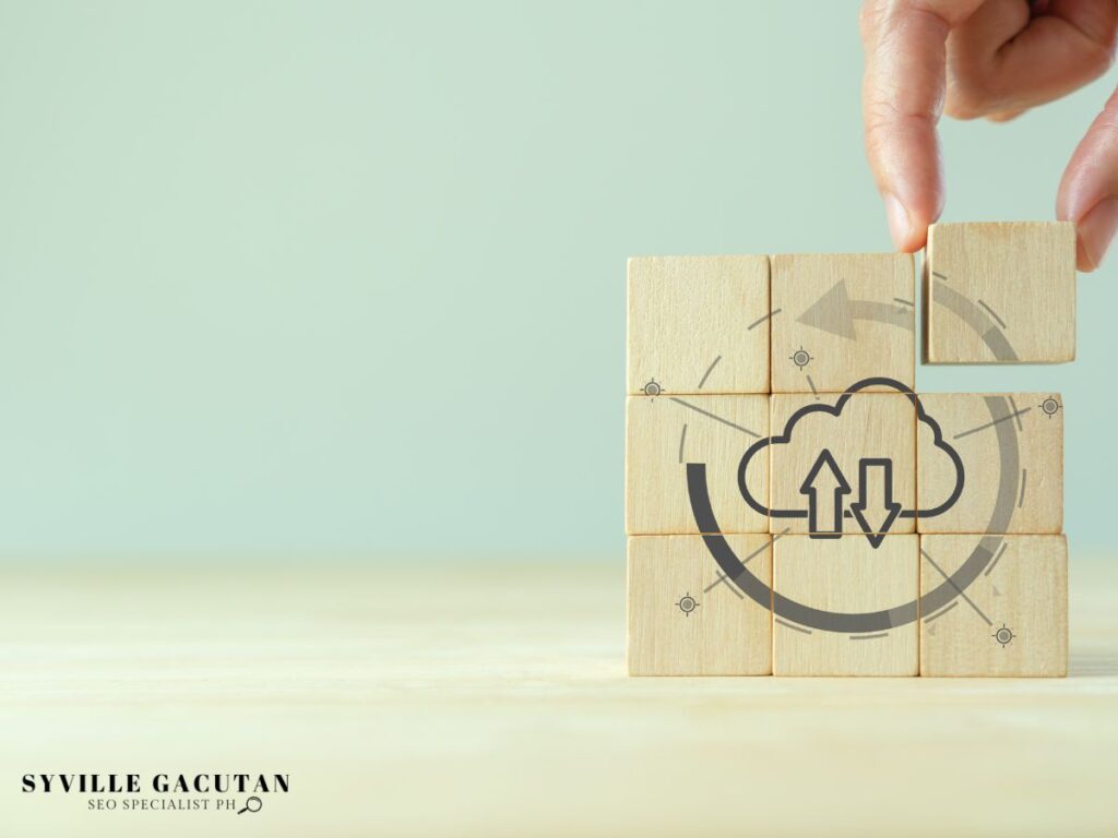 Hand placing wood blocks with cloud and data arrows symbolizing.