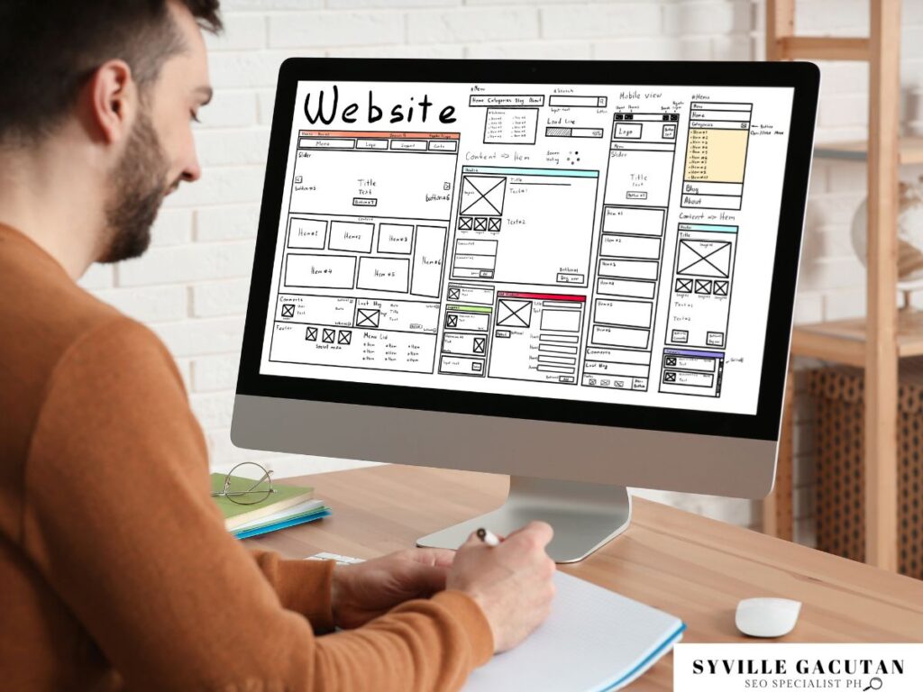 Designer creating a website mockup on a large screen.