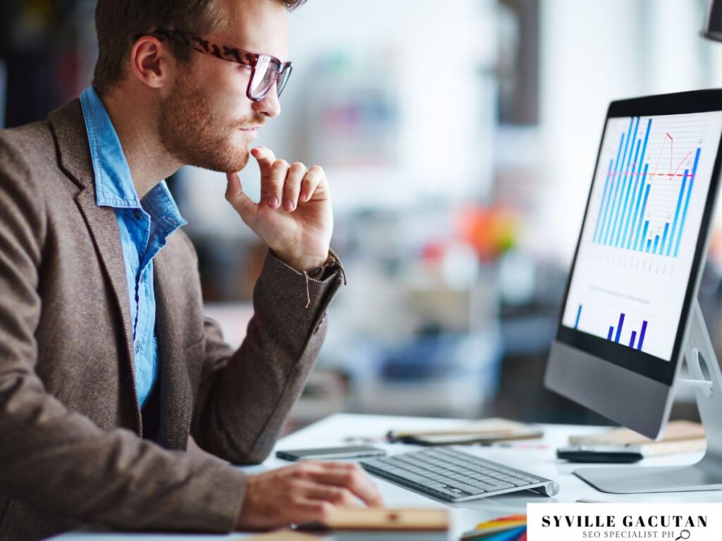 Man analyzing charts on a computer monitor.