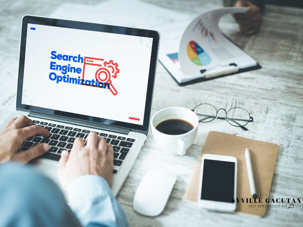 Person working on laptop showing "Search Engine Optimization."