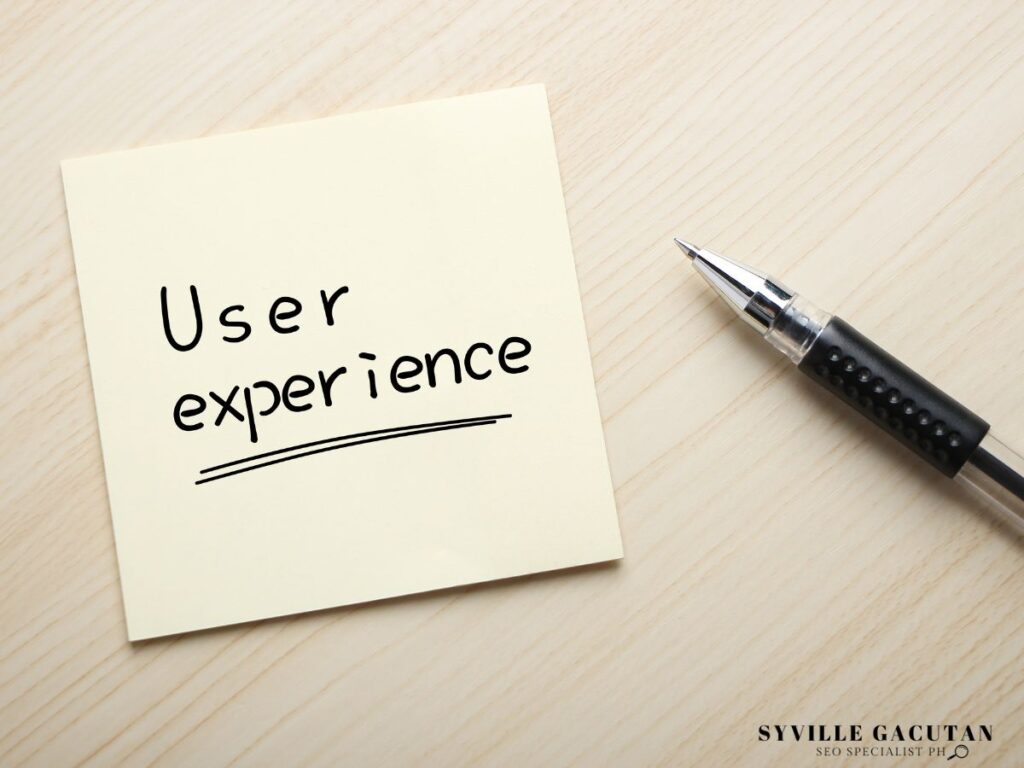 A white sticky note with "User experience" handwritten text and a black pen.