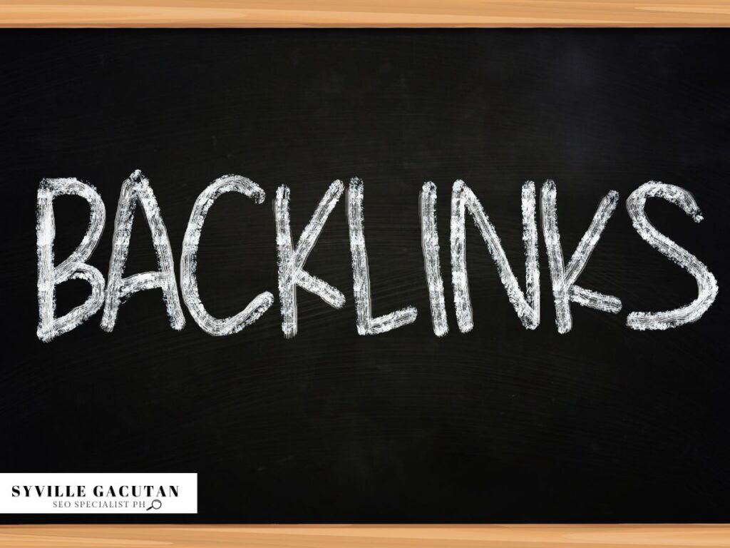 The word "BACKLINKS" written in chalk on a black chalkboard with wooden frame borders.