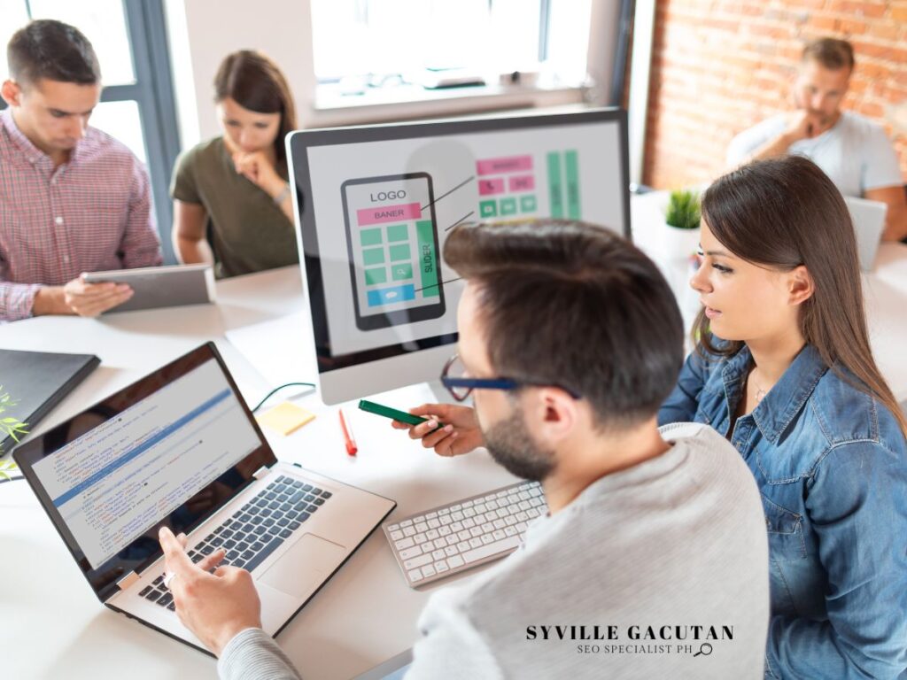 Team discussing a mobile app layout on a computer screen